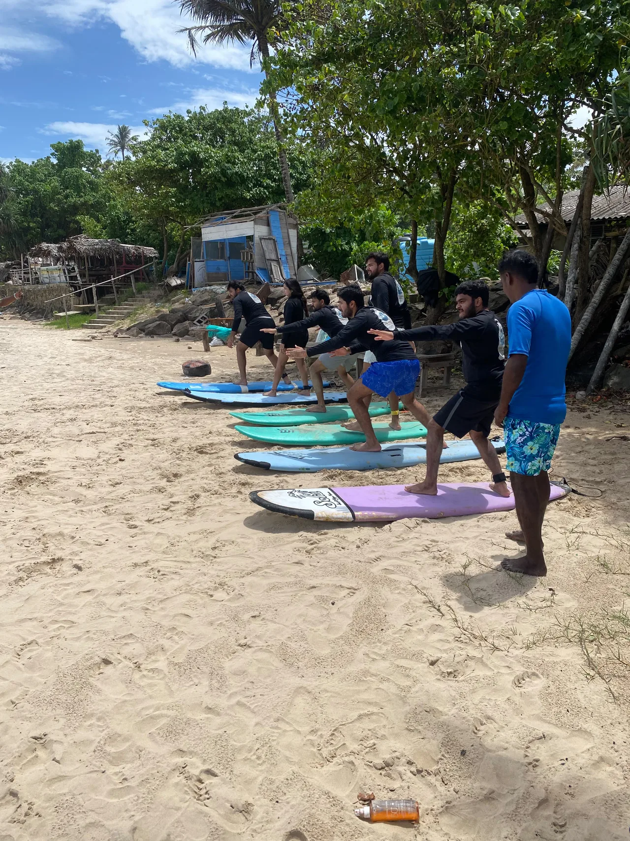 Beginner surfers practising with their boards on the sand